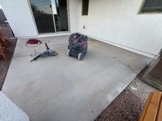 Covered patio slab being ground with a floor grinder and vacuum