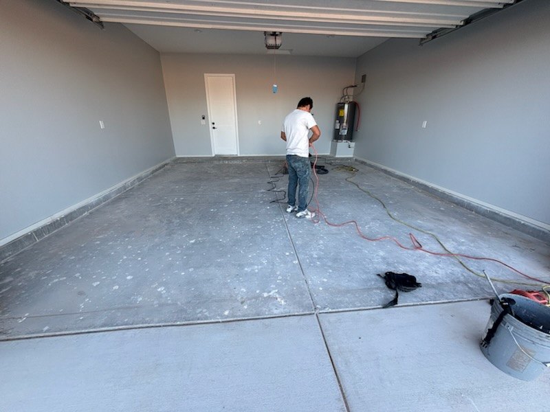 Crew member preparing a garage slab before coating
