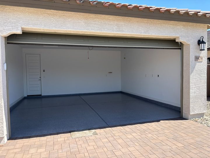 Finished grey flake garage floor seen from the driveway with the door open