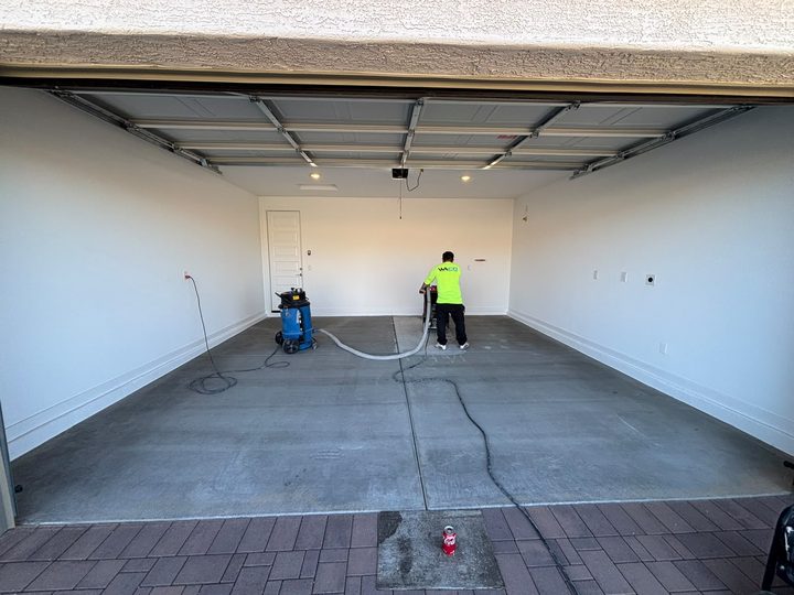 AMR crew vacuuming a bare garage slab before coating